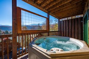 a jacuzzi tub on a balcony with a view at Spacious Smokies Cabin - Hot Tub with Mountain Views in Gatlinburg