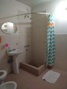 a bathroom with a sink and a shower with a shower curtain at Duplex Playa Unión in Playa Unión
