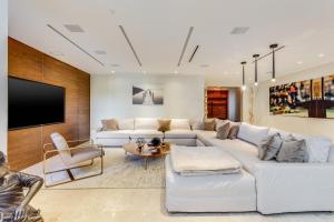 a living room with a white couch and a tv at Villa Roxi in Miami