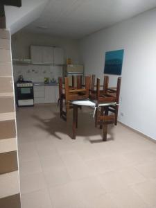 a dining room with a table and chairs and a kitchen at Duplex Playa Unión in Playa Unión