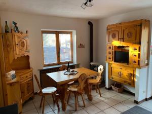 eine Küche mit einem Holztisch und Stühlen in der Unterkunft Appartamento Valtournenche in Valtournenche