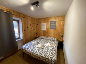 ein Schlafzimmer mit einem Bett in einem Zimmer mit Holzwänden in der Unterkunft Appartamento Valtournenche in Valtournenche
