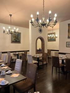 uma sala de jantar com mesas e cadeiras e um lustre em Hotel Schnookeloch em Heidelberg