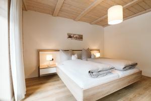 a bedroom with a white bed and a wooden ceiling at Apartment Dietrich Sylvia in Mellau