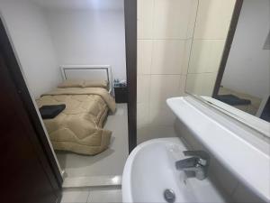 a bathroom with a bed and a sink and a mirror at Heart of Abu Dhabi - Nice Affordable Master Room in Abu Dhabi