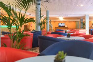 a restaurant with red and blue chairs and tables at Hotel Garda Bellevue in Limone sul Garda