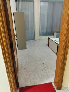 Zimmer mit einer Tür, die zu einem Zimmer mit einem roten Teppich führt in der Unterkunft Vintage Apartment in Abu Dhabi