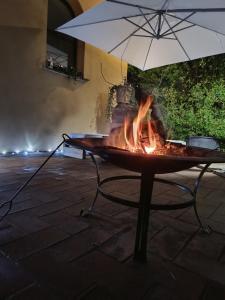 a fire pit with an umbrella on a table at Ripa D'Era in Capannoli