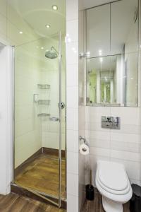 La salle de bains est pourvue de toilettes et d'une douche en verre. dans l'établissement GA-Old Town&Podwale, à Varsovie