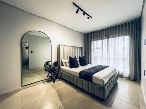 een slaapkamer met een groot bed en een spiegel bij City Sky Line View .Melrose,Rosebank ,Sandton in Johannesburg