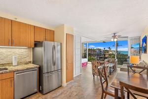 a kitchen with a stainless steel refrigerator and a dining room at Mana Kai 410 - Ocean front at Keawakapu Beach, AC in Wailea