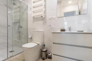 La salle de bains blanche est pourvue d'une douche et de toilettes. dans l'établissement Modern comfy-1bedroom 1bathroom-Prosperidad, à Madrid
