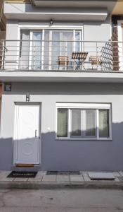 a white building with a door and a balcony at NINA'S HOUSE in Tríkala