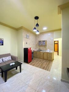 ein Wohnzimmer mit einem Sofa und einem roten Kühlschrank in der Unterkunft ديار البساتين المنسك للشقق الفندقية - Diyar Al Basateen Hotel Apartments in Abha