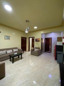 アブハにあるديار البساتين المنسك للشقق الفندقية - Diyar Al Basateen Hotel Apartmentsのソファとテーブル付きの広いリビングルーム