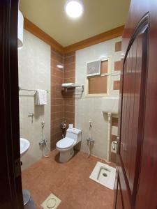 a bathroom with a toilet and a sink at ديار البساتين المنسك للشقق الفندقية - Diyar Al Basateen Hotel Apartments in Abha