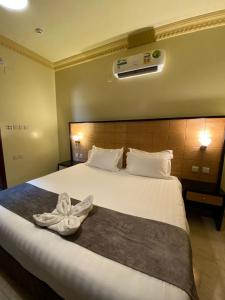 a hotel room with a bed with a towel on it at ديار البساتين المنسك للشقق الفندقية - Diyar Al Basateen Hotel Apartments in Abha