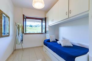 a bedroom with a blue bed and a window at Appartamento Sandra Trilo - MyHo Casa in Vasto