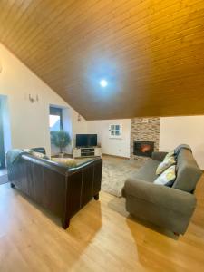 a living room with a leather couch and a fireplace at CASA do AÇÔR in Aldeia das Dez