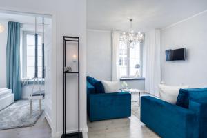 a living room with blue furniture and a mirror at Elite Apartments Old Town Suite in Gdańsk