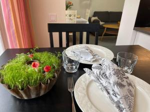 a table with two plates and a bowl with flowers in it at Satavuotias helmi Mäntässä in Mänttä