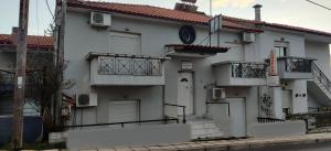 a white building with balconies on a street at Skordas Comfy Rent Rooms in Thessaloniki