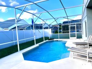 a swimming pool with a glass roof on a house at Brittany - Perfect 3 BR Pool Home in Kissimmee