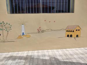 a painting of a house and a windmill on a wall at SOLAR HOSTEL PARNAIBA in Parnaíba