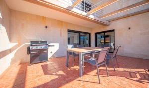 a kitchen with a table and a stove and chairs at TarracoHomes - TH130 Casa Golf Costa Dorada in Catllar