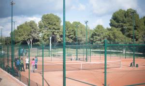 a group of people standing on a tennis court at TarracoHomes - TH130 Casa Golf Costa Dorada in Catllar