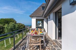 a table on the balcony of a house at Cadre privilégié et vue mer à Fréhel in Fréhel