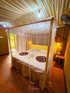 a bedroom with a canopy bed in a room at Wild Safari Clay House in Udawalawe