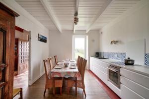ein Esszimmer mit einem Tisch und Stühlen in einer Küche in der Unterkunft Charmante maison pour un sejour detendant in Tréffiagat