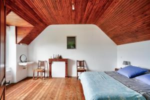 a bedroom with a bed and a wooden ceiling at Pays bigouden - Charmante maison en pierre pour 6 in Tréffiagat