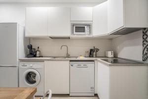 a kitchen with white cabinets and a washer and dryer at Modern- 1 Bd 1,5 Bth- Delicias Atocha in Madrid