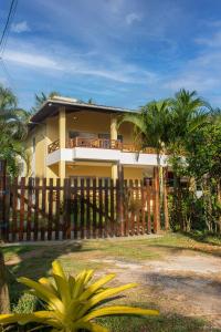 a house with a wooden fence in front of it at Casabela Sargi Serra Grande in Uruçuca