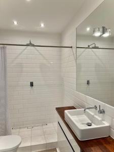 Baño blanco con lavabo y aseo en Apartament Relax Neptun Park en Gdansk
