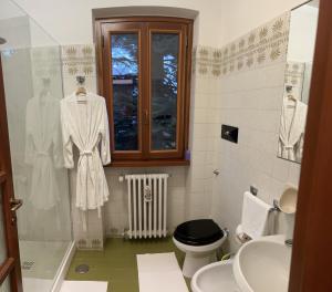 ein Bad mit einem Waschbecken, einem WC und einem Fenster in der Unterkunft Villa Dei Cedri in Asso