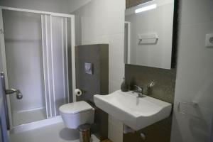 a bathroom with a sink and a toilet and a mirror at Hostel Rossio Alcobaça in Alcobaça