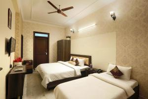 a hotel room with two beds and a ceiling fan at Hotel The Sunrise View - Corporate Stay Hotel in Noida