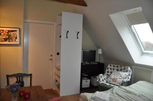 a bedroom with a white door and a chair and a table at Aplagårdens vingård in Helsingborg