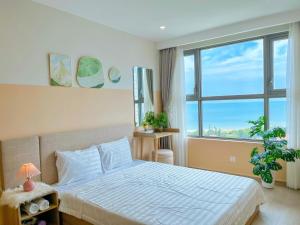 une chambre avec un lit et une grande fenêtre dans l'établissement The Sóng Apartment Vũng Tàu-RUBYVILLA, à Vung Tau 237 autres photos
