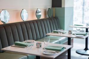 uma sala de jantar com duas mesas e espelhos em The Laura Hotel, Houston Downtown, Autograph Collection em Houston