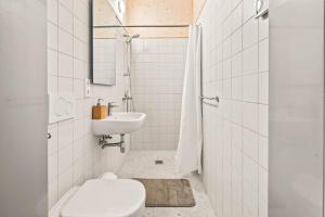 a white bathroom with a toilet and a sink at Maison Lasauvage in Differdange