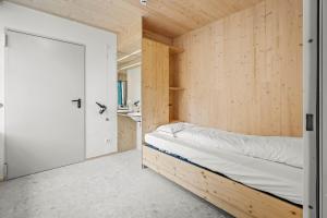 łóżko w pokoju z drewnianą ścianą w obiekcie Maison Lasauvage w mieście Differdange