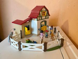 ein Spielzeughaus mit einer Gruppe von Menschen und einem Pferd in der Unterkunft Revival Ranch Ferienhaus in Büllingen