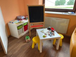 ein Spielzeugzimmer mit einem Tisch und einer Tafel in der Unterkunft Revival Ranch Ferienhaus in Büllingen