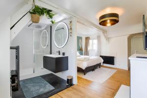ein Bad mit einem Waschbecken und ein Bett in einem Zimmer in der Unterkunft Appartement avec vue sur le château in Caen