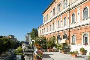 a large brick building with potted plants in front of it at Hotel Iris in Perugia