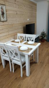 a white table with white chairs and a television at Sadyba Chertizh in Tatariv